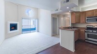 Living Room with Balcony - Academy Village Apartments in Los Angeles, California