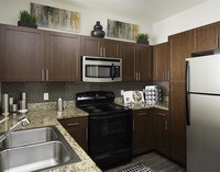 Designer kitchens with granite countertops with black and stainless appliances - Talavera Apartamentos in Denver, Colorado
