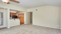 Kitchen and Carpeted Living Room - Deerwood Apartments in San Diego, California