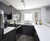 Newly updated kitchens include stainless steel appliances and a glass tile backsplash - Lore South Mountain Apartments in Phoenix, Arizona