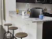 Prep and create on durable luxury. Kitchens and baths at Skye have creamy polished granite countertops. - Skye Apartamentos in Vista, California