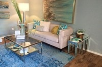 Living rooms featuring wood-style flooring, a ceiling fan, and slider doors that lead to your private patio/balcony. - Domain 3201 Apartamentos in Tucson, Arizona