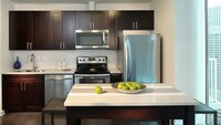 Kitchen with Stainless Steel Appliances and Quartz Countertops - Skyhouse Denver Apartamentos in Denver, Colorado