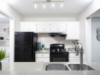 Crisp white cabinets and granite inspired counters in our newly renovated kitchens give them a modern feel - Array South Mountain Apartments in Phoenix, Arizona