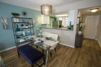 Spacious dining area with wood-style flooring and ceiling fan. - The Bentley at Maitland Apartments in Orlando, Florida