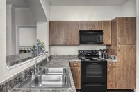 Beautiful designer cabinets and sleek black appliances bring style to your home - Reserve At Beachline Apartments in Orlando, Florida
