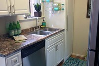 Fully applianced kitchens with updated counter tops and cabinetry, dishwasher, and cutout to living area. - Domain 3201 Apartamentos in Tucson, Arizona