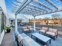 Our outdoor lounge features both table and lounge seating under a pergola with string lights and speakers - Waldwick Station Apartments in Waldwick, New Jersey
